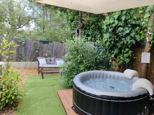 un bain à remous au milieu d'une cour dans l'établissement Joli studio climatisé avec jacuzzi privé et entrée indépendante, à Fréjus