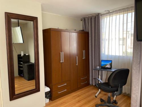 une pièce avec un bureau, une chaise et un miroir dans l'établissement The Chill Spot, à Arequipa