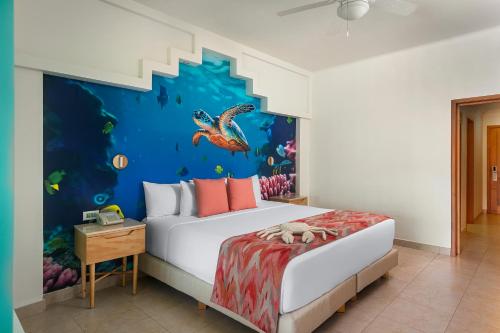 a bedroom with a bed with a fish mural at Iberostar Selection Paraíso Maya - All Inclusive in Puerto Morelos