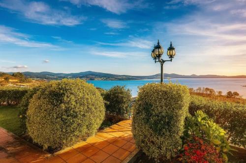 a street light and bushes with a view of the water at Chalet en Sanxenxo con hermosas vistas y gran privacidad in Sear