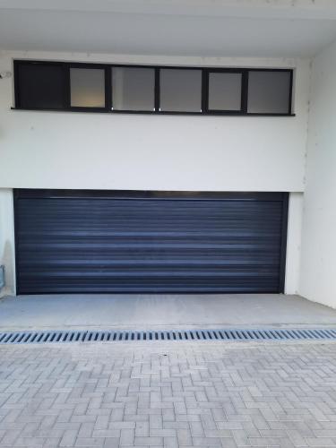 a pair of garage doors on a white building at Pavlovic Luxury Spa in Vrnjačka Banja