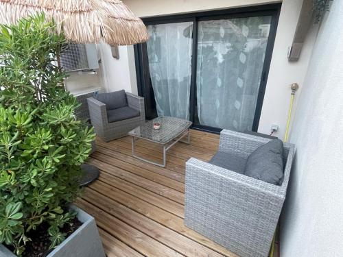 a balcony with two chairs and a table at Maison Cosyli in Meyzieu