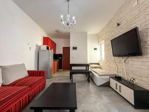 a living room with a red couch and a flat screen tv at Lighthouse in Vodice