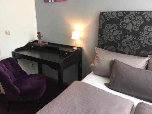 a bedroom with a desk and a bed and a chair at Hotel Heddernheimer Hof in Frankfurt/Main