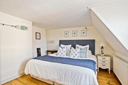 a bedroom with a bed with blue and white pillows at Central Lymington Retreat in Lymington