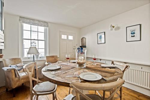 a dining room with a wooden table and chairs at Central Lymington Retreat in Lymington