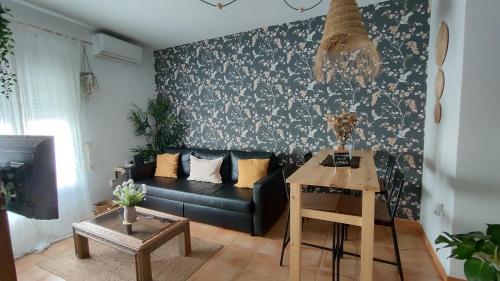 a living room with a black couch and a table at Azahares Apartamento turístico in El Bosque
