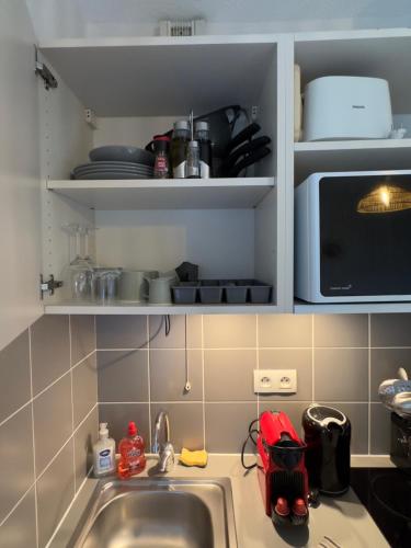 a kitchen counter with a sink and a microwave at Appart'Hôtel avec Balcon et Netflix - Avignon gare TGV Confluence in Avignon