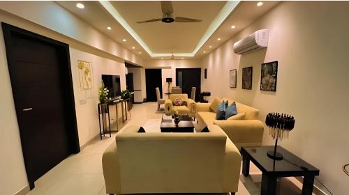 a living room with couches and a ceiling at Elysium Retreat Facing Centaurus Mall Islamabaad in Islamabad