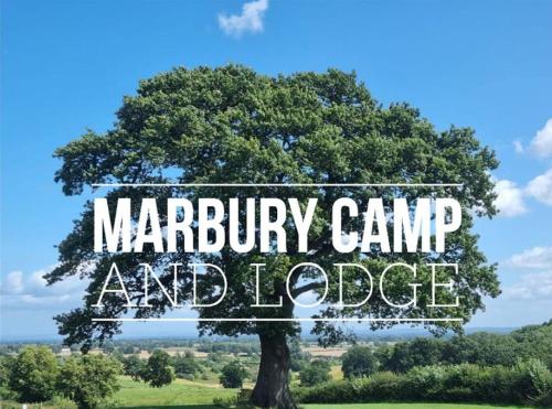 a tree in a field with the words marbury camp and lodge at Marbury Camp and Lodge in Whitchurch
