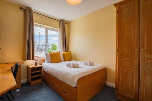 une chambre avec un lit avec une fenêtre et un bureau dans l'établissement Spacious & Affordable 3 Bed Apt, à Galway