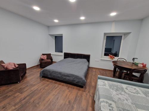 a bedroom with a bed and a table and chairs at Laumės dvaro svečių namai in Kruopinė