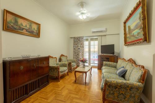 a living room with a couch and chairs and a tv at Athens center traditional & classic 2BR apartment in Mesochórion