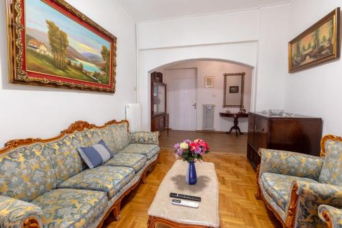 a living room with a couch and a table at Athens center traditional & classic 2BR apartment in Mesochórion