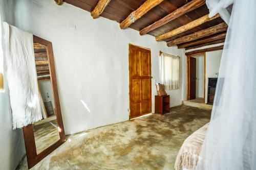 a bedroom with a bed and a wooden door at Eco Bañitas Tulum in Tulum