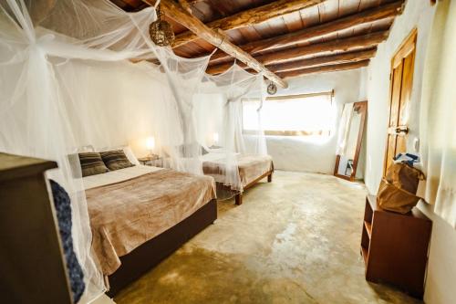 a bedroom with a large bed and a large window at Eco Bañitas Tulum in Tulum