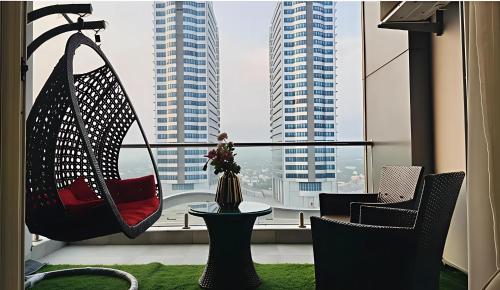 a balcony with two chairs and a table and a window at Elysium Retreat Facing Centaurus Mall Islamabaad in Islamabad