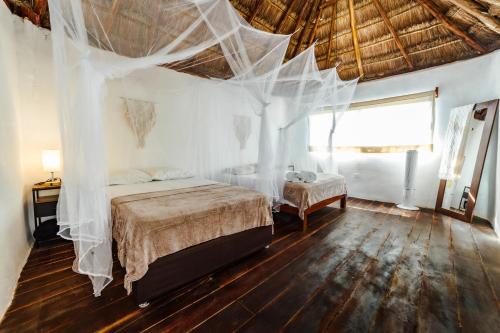 a bedroom with a bed with mosquito nets on it at Eco Bañitas Tulum in Tulum