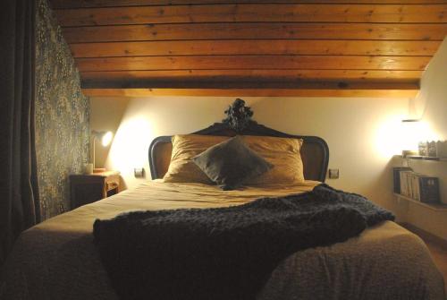 a bedroom with a large bed with a wooden ceiling at Lodge Les Rêveries de Charles in Plancher-les-Mines