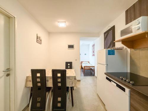 a kitchen with a white refrigerator and a table and chairs at Lighthouse in Vodice