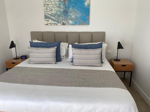 a bedroom with a bed with blue and white pillows at Unit 3J Signature Suites, Lafayette Megaworld in Iloilo City