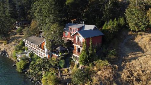 an aerial view of a house on a hill next to the water at Salishan Tree House Suite in Cowichan Bay