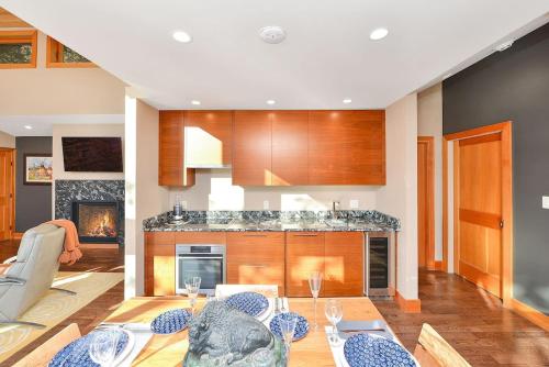 a living room with a table and a kitchen at Salishan Tree House Suite in Cowichan Bay