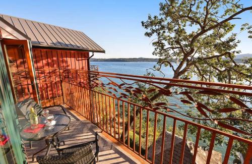 a balcony with a table and a view of the water at Salishan Tree House Suite in Cowichan Bay