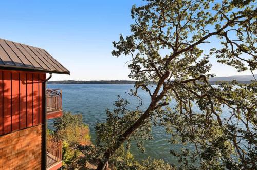 a view of a lake from a house with a tree at Salishan Tree House Suite in Cowichan Bay