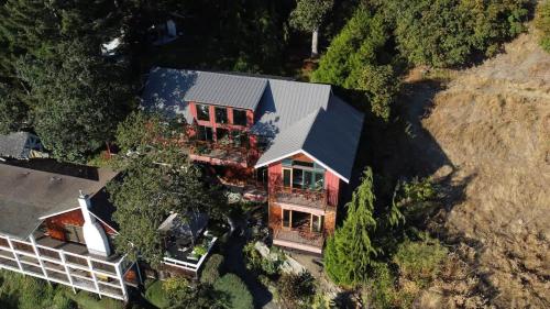 an overhead view of a house with a black roof at Salishan Tree House Suite in Cowichan Bay
