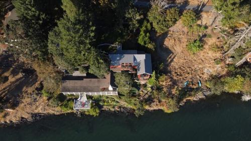 an aerial view of a house on the shore of the water at Salishan Tree House Suite in Cowichan Bay