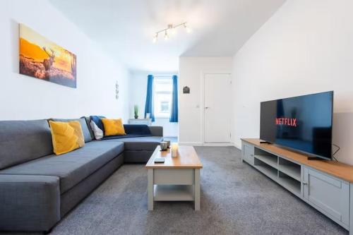 a living room with a couch and a flat screen tv at Morden 2BR Apt with city views in Manchester