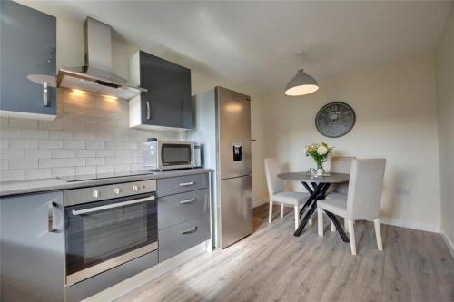 a kitchen with a table and a microwave and a stove at Morden 2BR Apt with city views in Manchester