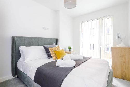 a bedroom with a large bed with towels on it at Morden 2BR Apt with city views in Manchester