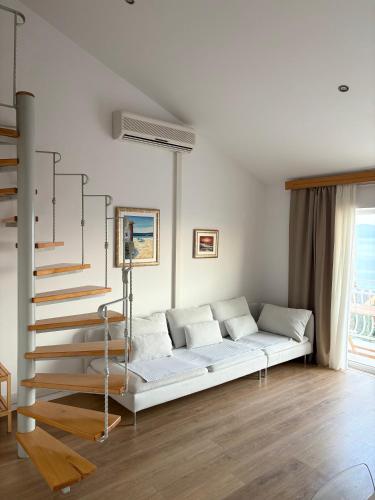 a white couch in a living room with a staircase at Apartment Araucaria Gallery in Crikvenica