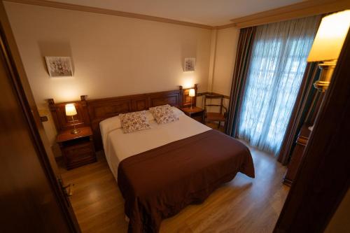 a hotel room with a bed and a window at Hotel Edelweiss in Camprodon