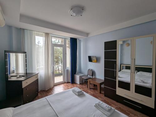 a bedroom with a bed and a desk and a mirror at Panorama hotel kobuleti in Kobuleti