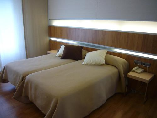 a bedroom with a large bed with a light on it at Hotel El Mesón in Javier