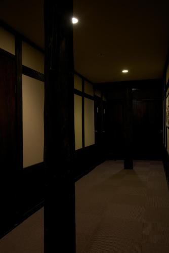 a dark room with a hallway with white walls at Minshuku Takizawa in Takayama