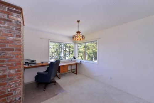 an office with a desk and a chair and a window at Pacific Coast Beach House in Sooke