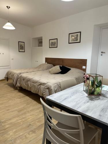 a bedroom with two beds and a table with chairs at Dimora del Teatro in Spoleto