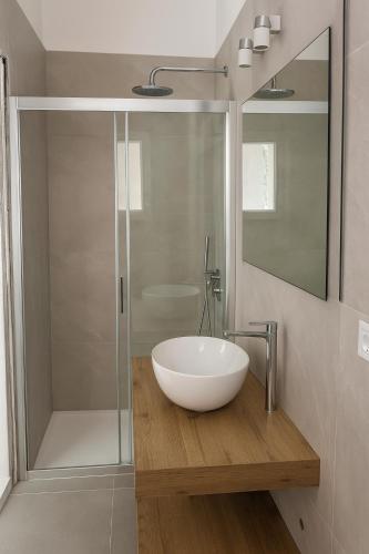 a bathroom with a bowl sink and a shower at Le dune relax con cucina & piscina in San Teodoro