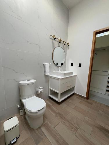 a bathroom with a toilet and a sink and a mirror at Rancho Macloy Hotel Spa & Social Events in Yautepec