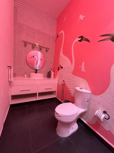 a pink bathroom with two flamingos on the wall at Rancho Macloy Hotel Spa & Social Events in Yautepec