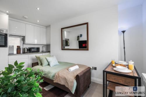 a small bedroom with a bed and a mirror at City Centre - Top Floor Luxury Apartment - Free Secure Small Car Parking - 5 Minute Walk to Beach & Station in Brighton & Hove