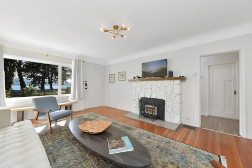 a living room with a fireplace and a tv at The Bayside Cottage in North Saanich