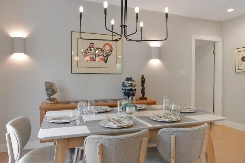 a dining room with a table with chairs and a chandelier at The Bayside Cottage in North Saanich