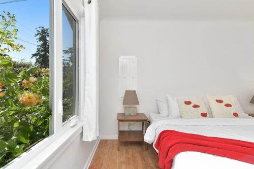 a bedroom with a bed and a window at The Bayside Cottage in North Saanich