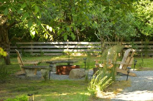 a park with two benches and a table and a tree at The Bayside Cottage in North Saanich