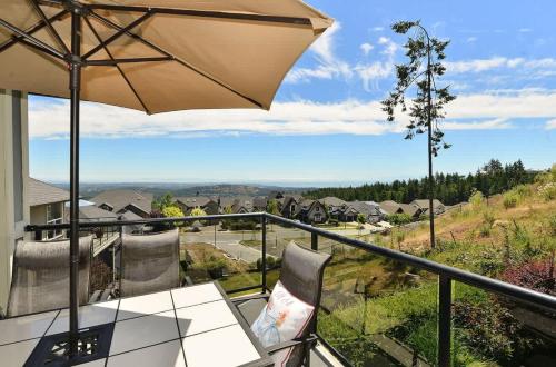 a balcony with a table and an umbrella at Nature's Gate Executive Estate in Victoria